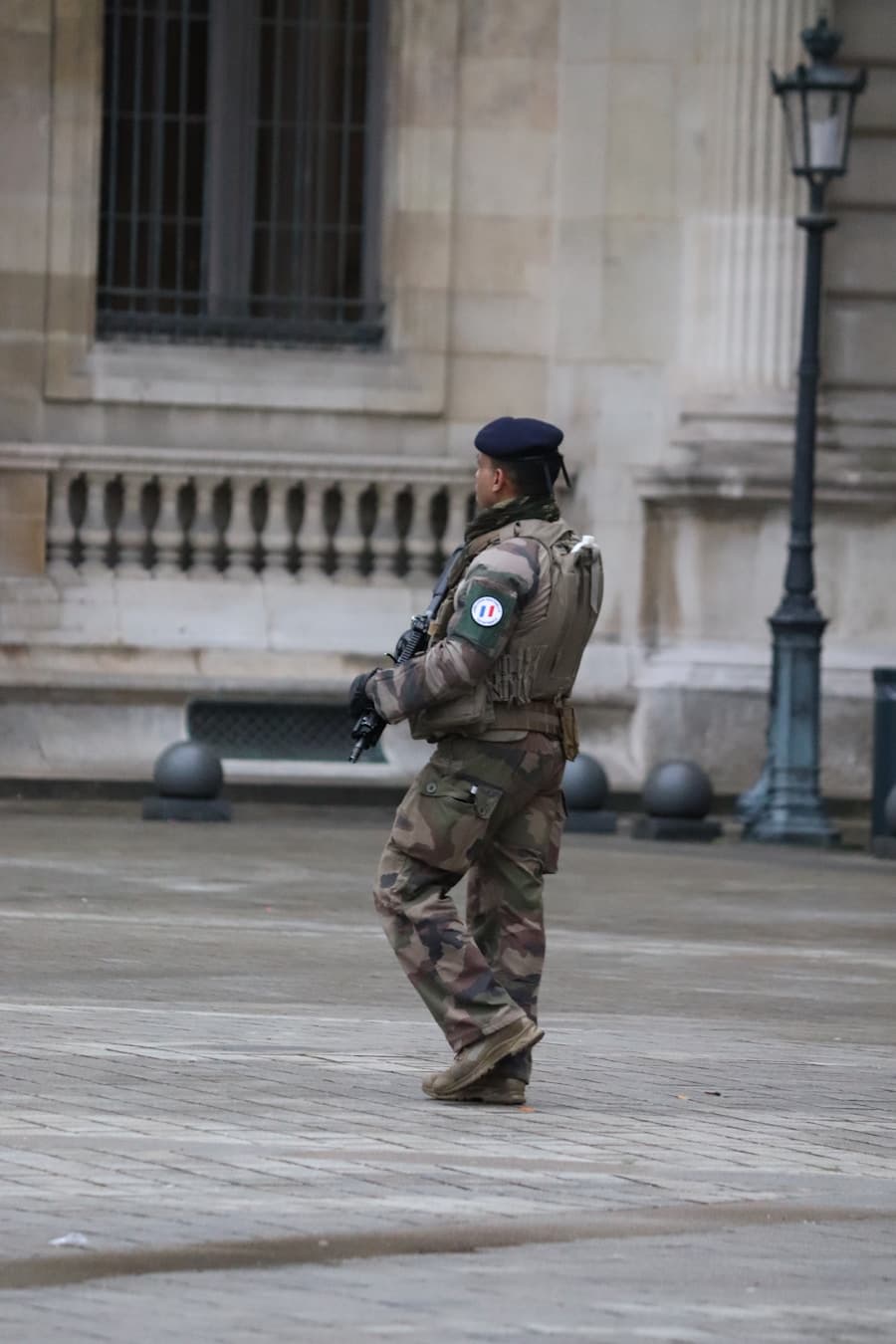 Militaire en patrouille devant un bâtiment officiel